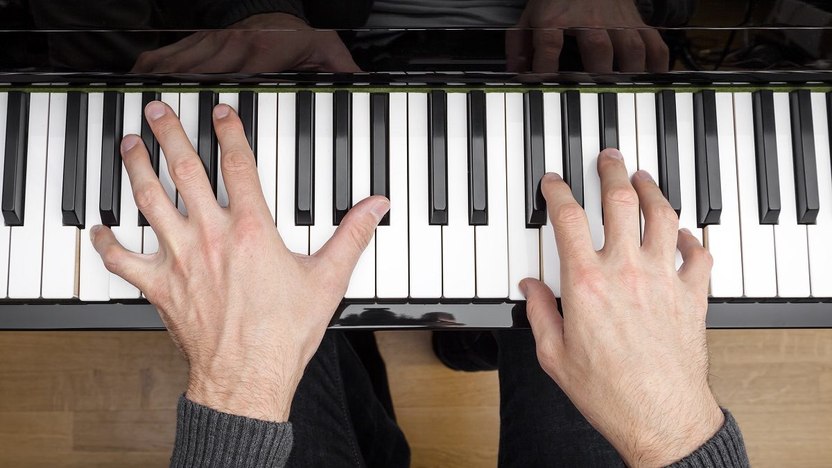 Pianino - widok z góry na ręce grające na pianinie
