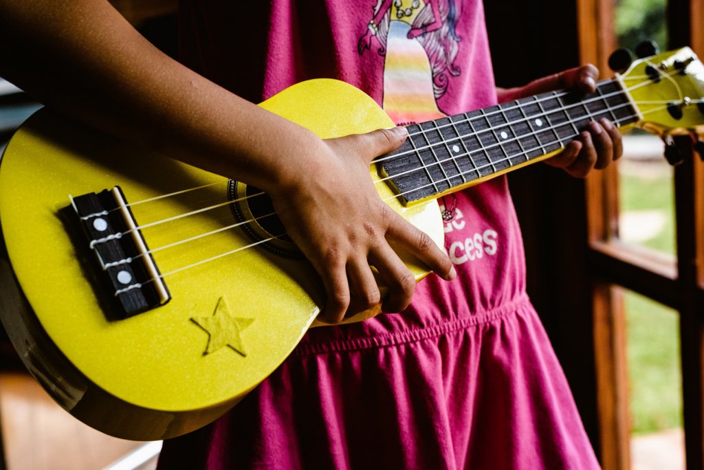 Dziewczynka trzymająca żółte ukulele z gwiazdką