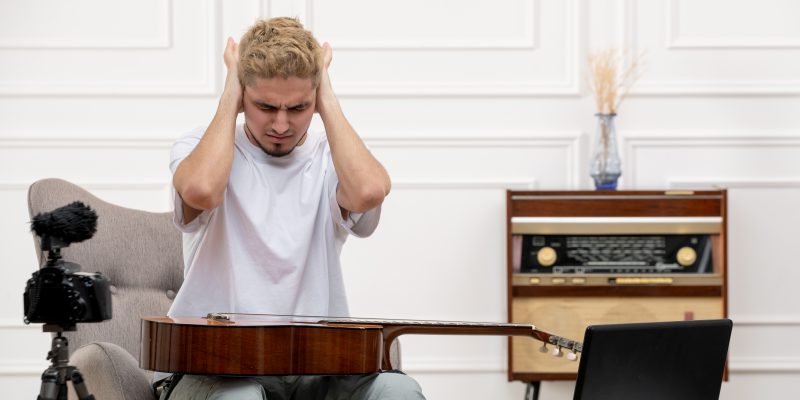 Zestresowany muzyk z gitarą na kolanach