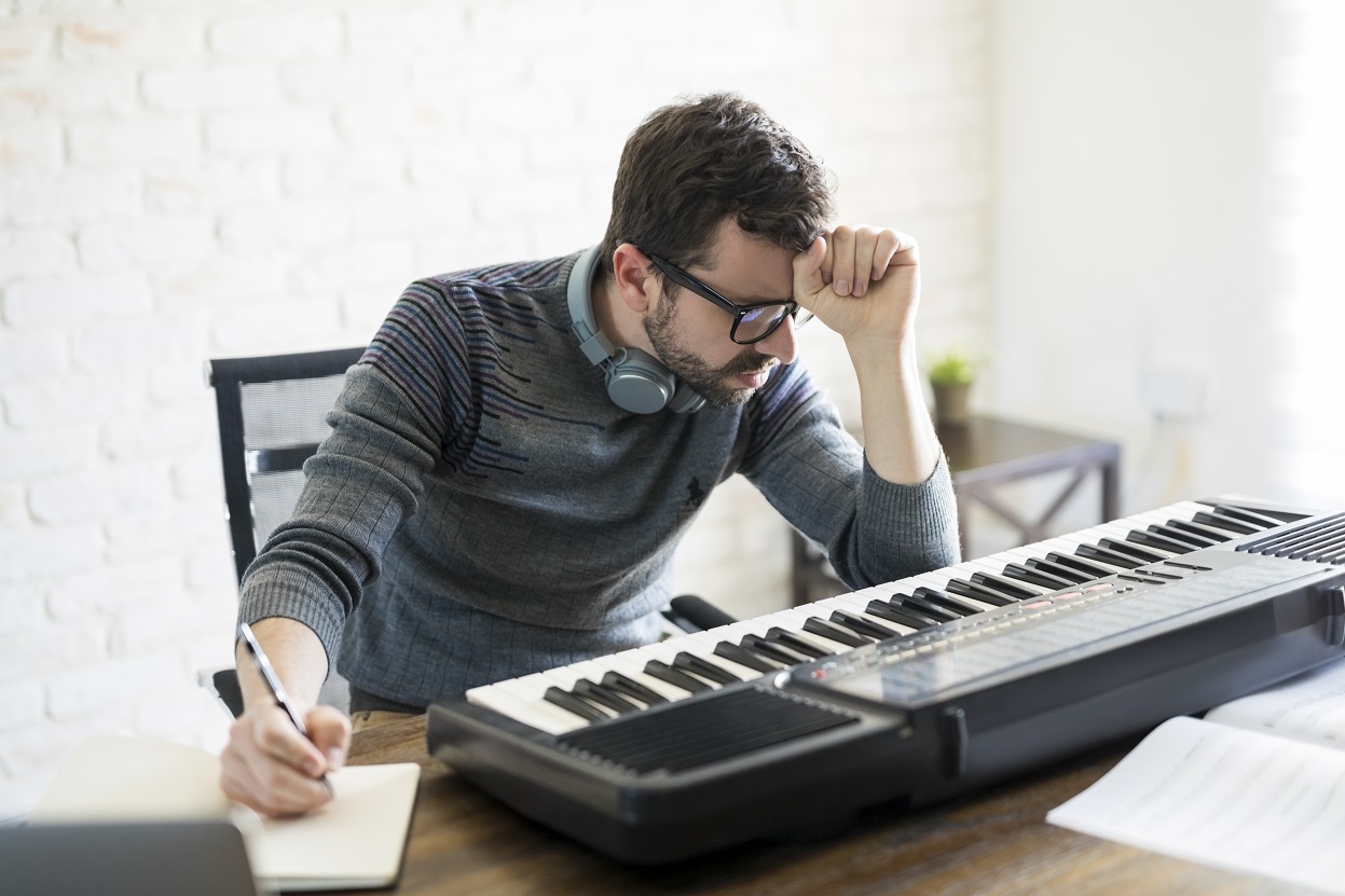 Intensywne myślenie - Muzyk pochylający się nad keyboardem