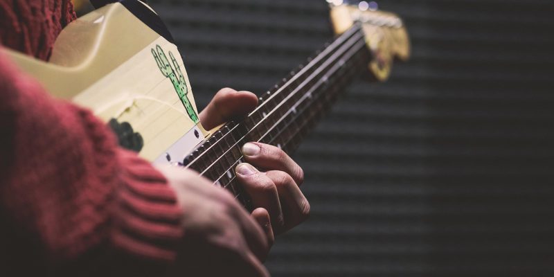 Osoba grająca na gitarze elektrycznej